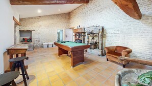 A spacious room with a pool table, a billiards table, and a stone wall. - Pet friendly home in NERE (NERE)