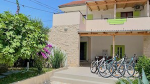 Edifici de dues plantes amb façana de pedra, un vestíbul cobert i una filera de bicicletes aparcades a l'exterior.