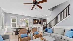 Una sala de estar amplia con comedor, cocina y escalera.