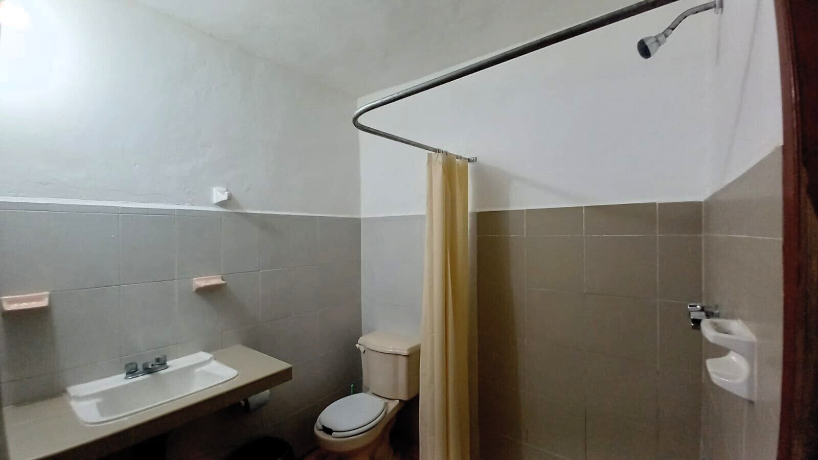 Une petite salle de bain avec des toilettes, un lavabo et une douche.