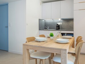 Enjoy meals at the dining table for four, equipped with a coffee maker and sink.