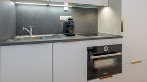 Une cuisine moderne équipée d’un four Bosch, d’une machine à café et d’un évier.