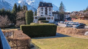 Un hôtel doté d’un grand bâtiment, d’un parking et ayant une montagne en toile de fond.