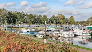 A marina with boats docked along the water, surrounded by trees and a grassy area. - 2 bedroom gorgeous home in Afferden (Afferden)