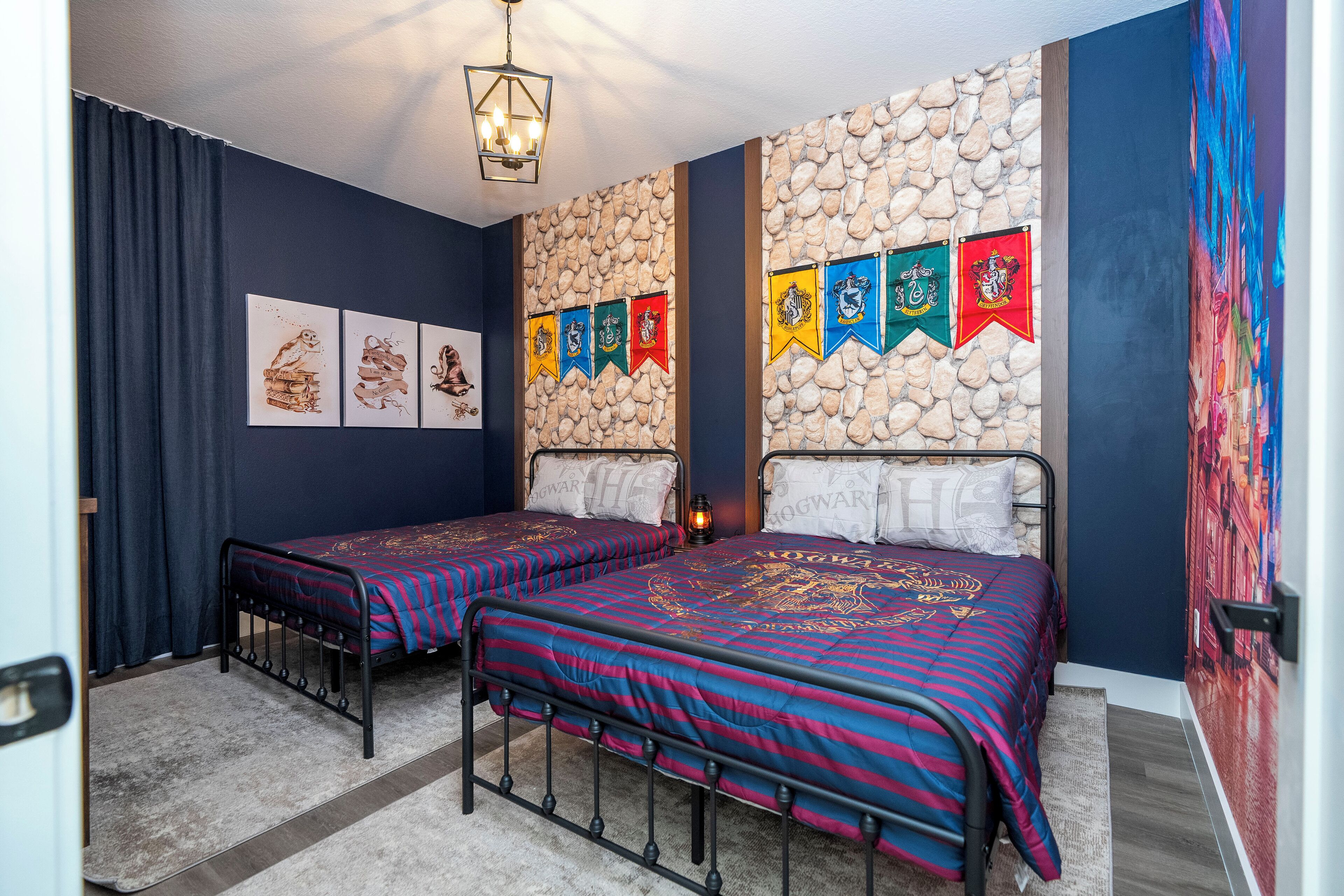 A bedroom with two beds, a stone wall, and a series of flags.