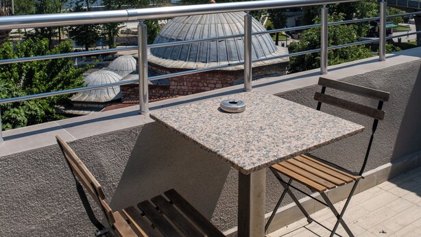 A terrace with a table and chairs, a view of a cityscape, and a body of water. - Sweet Hotel Istanbul (Istanbul)
