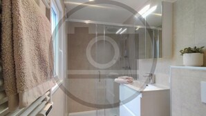A modern bathroom with a glass shower enclosure, a white sink, and a mirror above it. - Stunning home in Hellendoorn with WiFi (Hellendoorn)