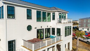 Ein zweistöckiges Haus mit Balkon, großen Fenstern und einer Garage.