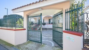 A gated entrance to a property with a tiled roof and a sign indicating 'Villa Carmine'.