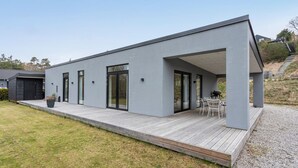 A modern house with a flat roof, large windows, and a covered patio area. - 3 bedroom lovely home in Ebeltoft (Ebeltoft)