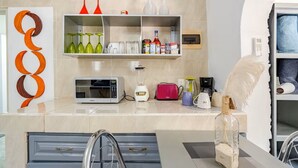 Een moderne keuken met een magnetron, broodrooster en diverse keukenbenodigdheden op het aanrecht.