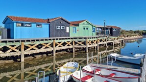 A wooden pier with colorful wooden buildings and boats docked at the end.