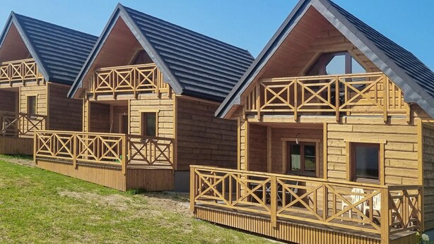 Een rij houten hutten met puntige daken en balkons.