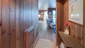 A wooden interior hallway with a dining area in the background. - Cozy home in Sjusjøen with sauna (Sjusjøen)