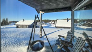 A snow-covered outdoor area with a swing set and wooden benches, overlooking a row of houses with snow-covered roofs. - Cozy home in Sjusjøen with sauna (Sjusjøen)