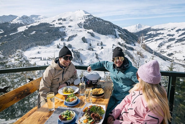 Guests can enjoy a casual meal outdoors with a mountain view.