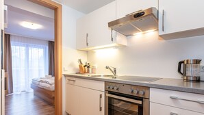Una cocina moderna con electrodomésticos de acero inoxidable, horno empotrado y cafetera.