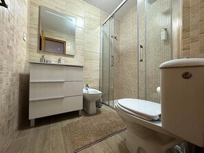 Bathroom features a toilet, shower, vanity, and sink.