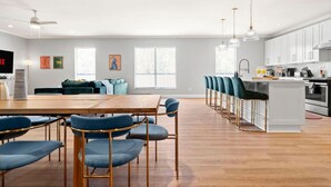 A modern kitchen with white cabinets, a central island, and bar stools.
