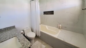 Une salle de bain avec des toilettes, un lavabo et une baignoire.