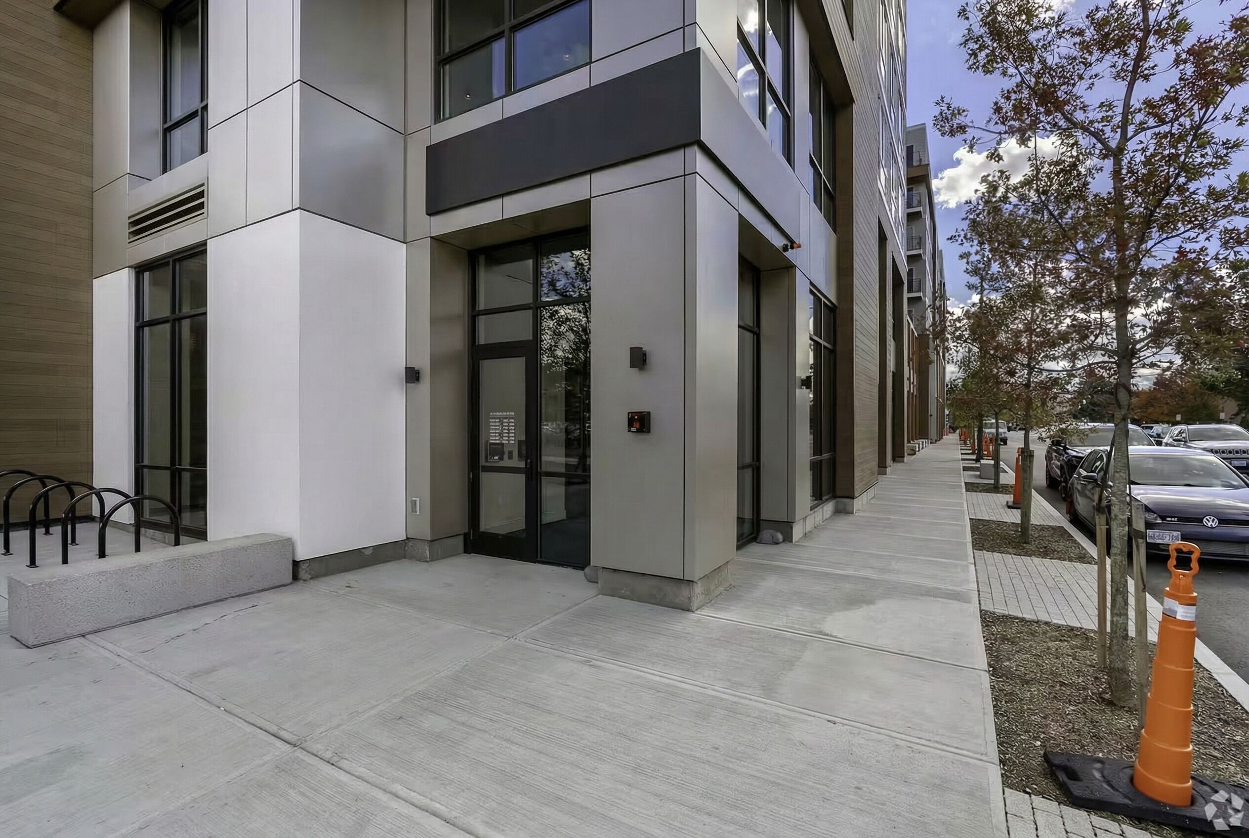 A modern building with a flat facade, large windows, and a concrete entrance area.