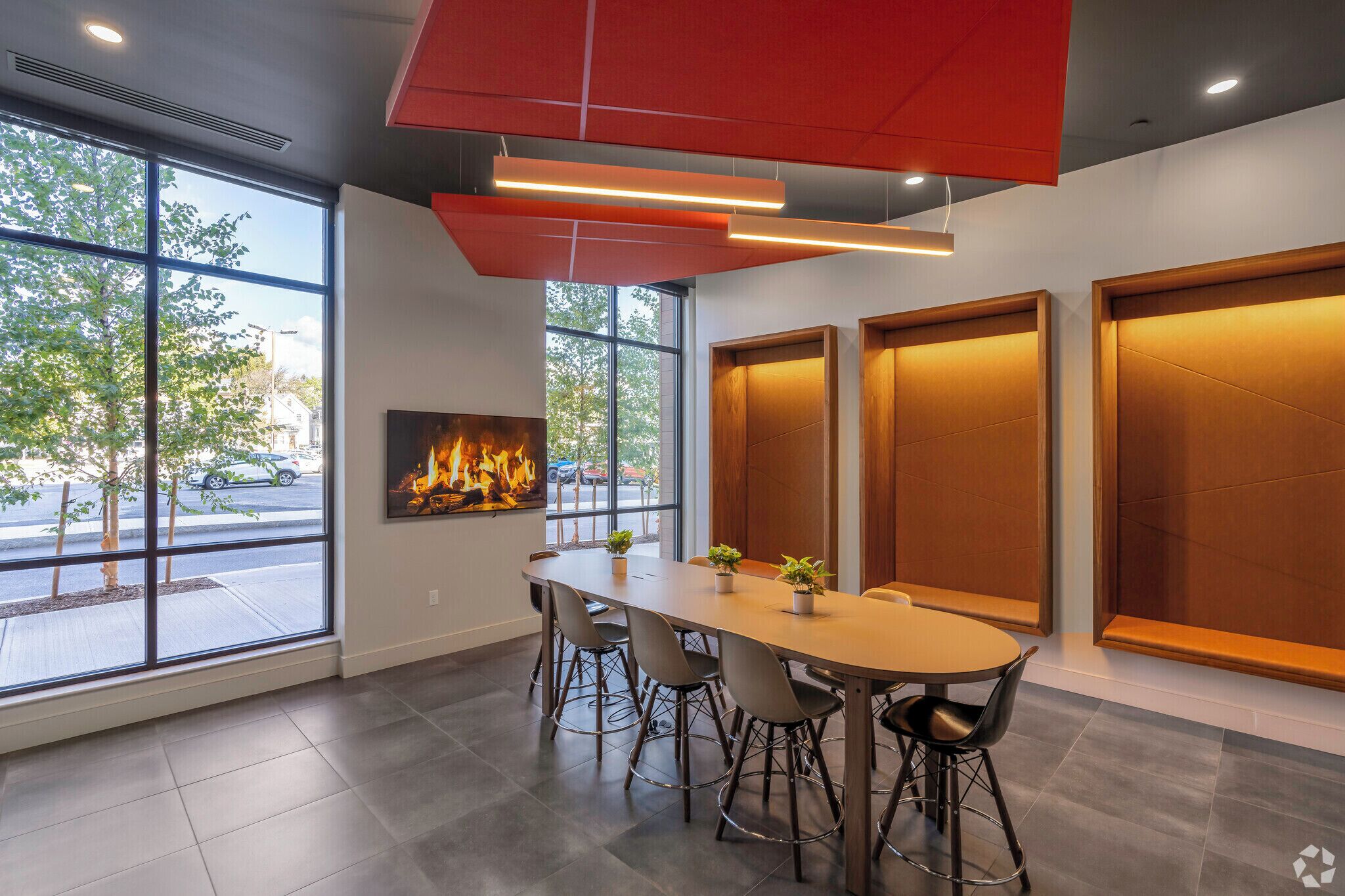 A modern conference room with a long table, chairs, and a fireplace.