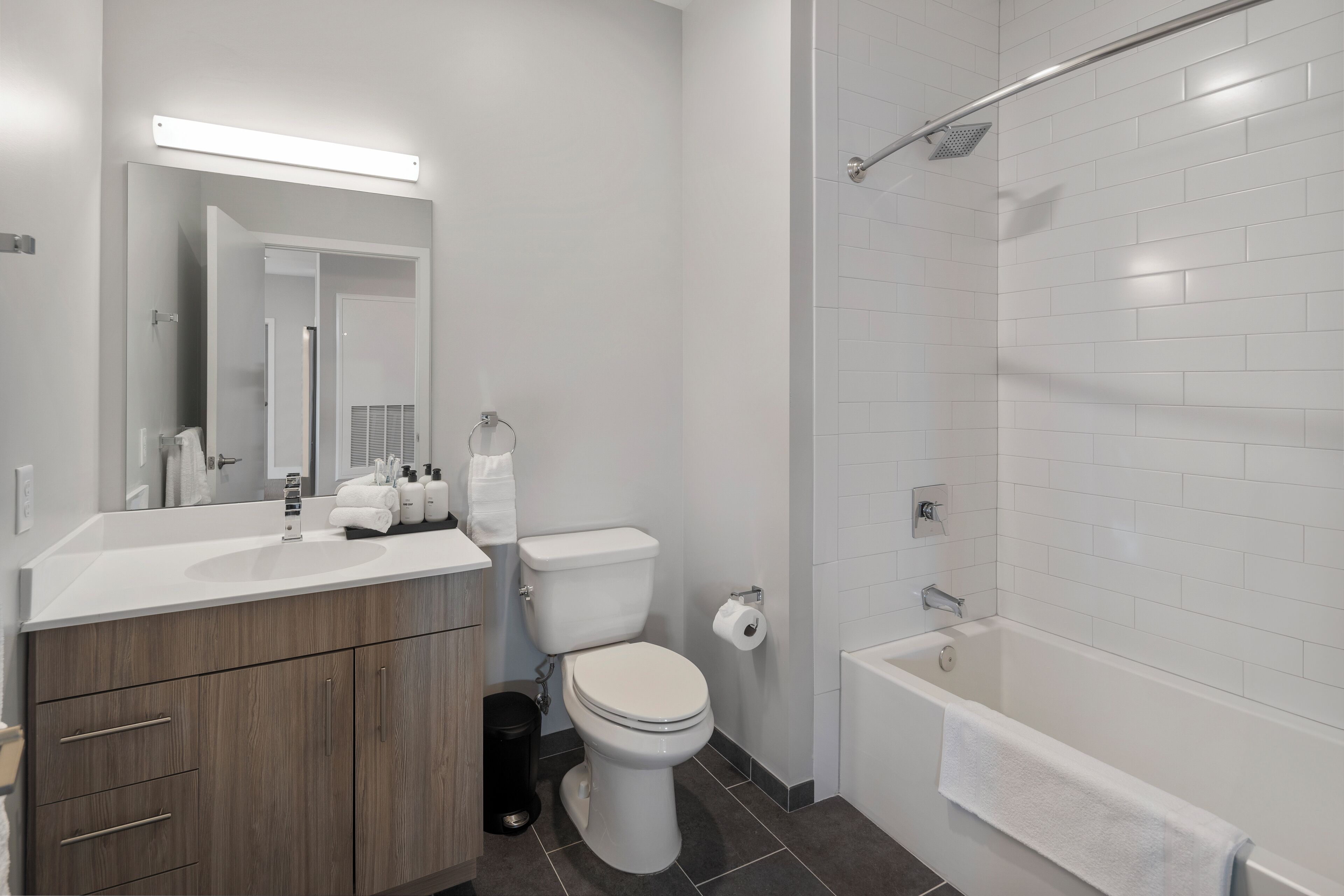 A modern bathroom with a white sink, toilet, and bathtub.
