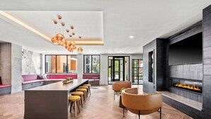 Une cuisine moderne dotée d’un îlot central, de tabourets de bar et d’une cheminée.