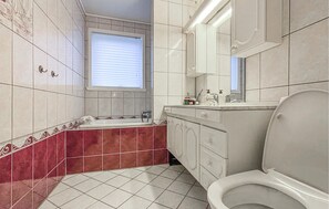 A bathroom with a toilet, sink, and bathtub. - 4 bedroom stunning home in Atløy (Atløy)