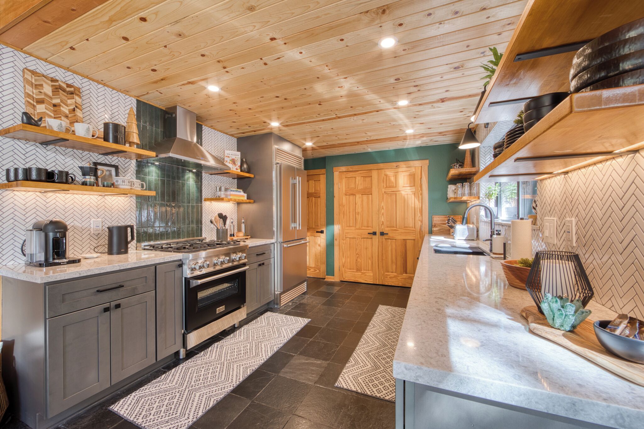 Una cocina moderna con armarios de madera, estufa de acero inoxidable y salpicadero con motivo de espiga.