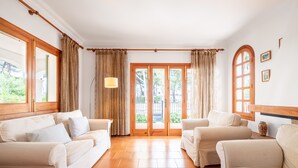 A room with two sofas, a wooden door, and a view of greenery outside. - Villa 'Anecs' with Private Garden, Wi-Fi and Air Conditioning (Muro)