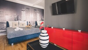 A modern bedroom with a cityscape mural, a large bed, a red dresser, and a flat-screen TV. - Dream 18 Przytulne Studio Centrum Bydgoszczy (Bydgoszcz)