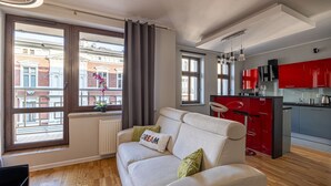 A modern apartment with a living room, kitchen, and large windows. - Dream 18 Przytulne Studio Centrum Bydgoszczy (Bydgoszcz)