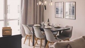 A modern dining area with a dark wooden table, grey upholstered chairs, and pendant lighting. - Humo Idealna Lokalizacja Centrum Gara (Poznan)