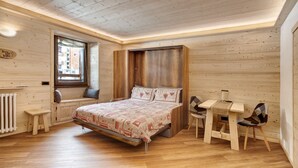 A wooden-paneled room with a bed, a small table, and a chair. - Apartment 'Centro Santa Caterina' with Mountain View (Santa Caterina)