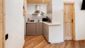A compact kitchen with wooden cabinets, a stainless steel range hood, and a microwave. - Apartment 'Centro Santa Caterina' with Mountain View (Santa Caterina)
