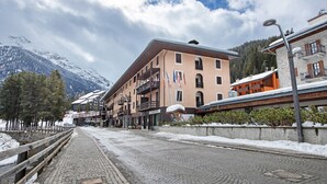 A cobblestone street with buildings, a wooden fence, and snow-covered ground. - Apartment 'Centro Santa Caterina' with Mountain View (Santa Caterina)
