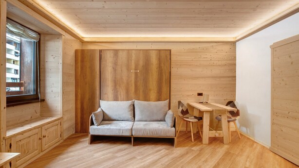 A wooden interior with a sofa, a table, and chairs. - Apartment 'Centro Santa Caterina' with Mountain View (Santa Caterina)