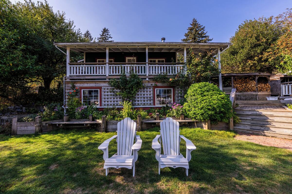Une maison à deux étages avec un porche à l’avant et une terrasse couverte.