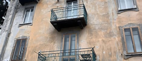 Un edificio de varios pisos con balcones, ventanas y una antena visible.