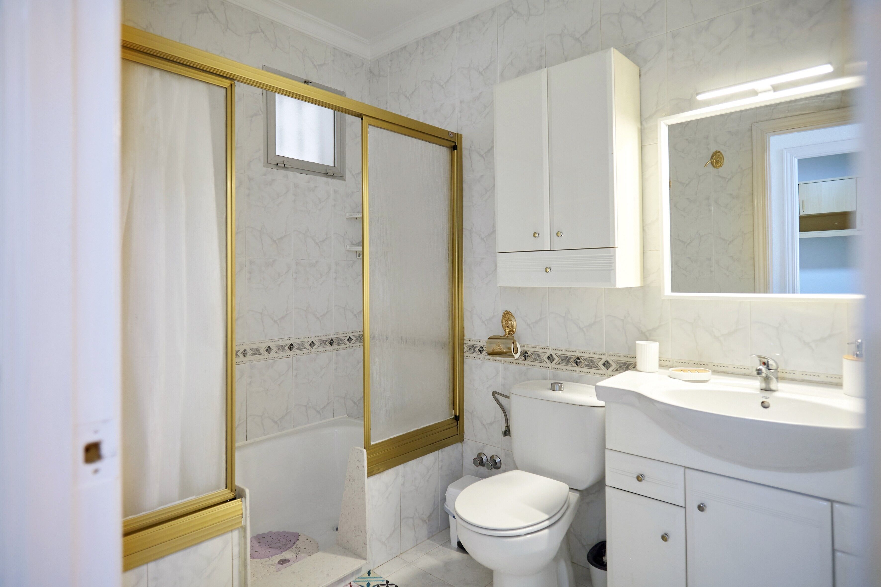 Ein Badezimmer mit Toilette, Waschbecken und Spiegel.