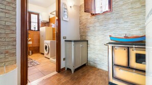 Une cuisine équipée d’un lave-linge, d’un placard et d’une cuisinière.