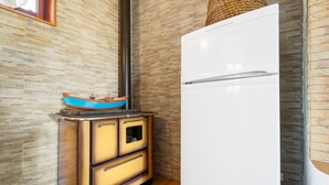Une cuisine avec un réfrigérateur blanc, une cuisinière et une casserole bleue sur la cuisinière.