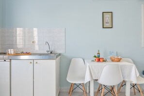 Une cuisine équipée d’un évier, de placards et d’un coin repas avec des chaises et une table.