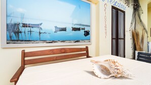Habitación con una ventana grande que muestra barcos en el agua, una cama y una pared con un letrero.