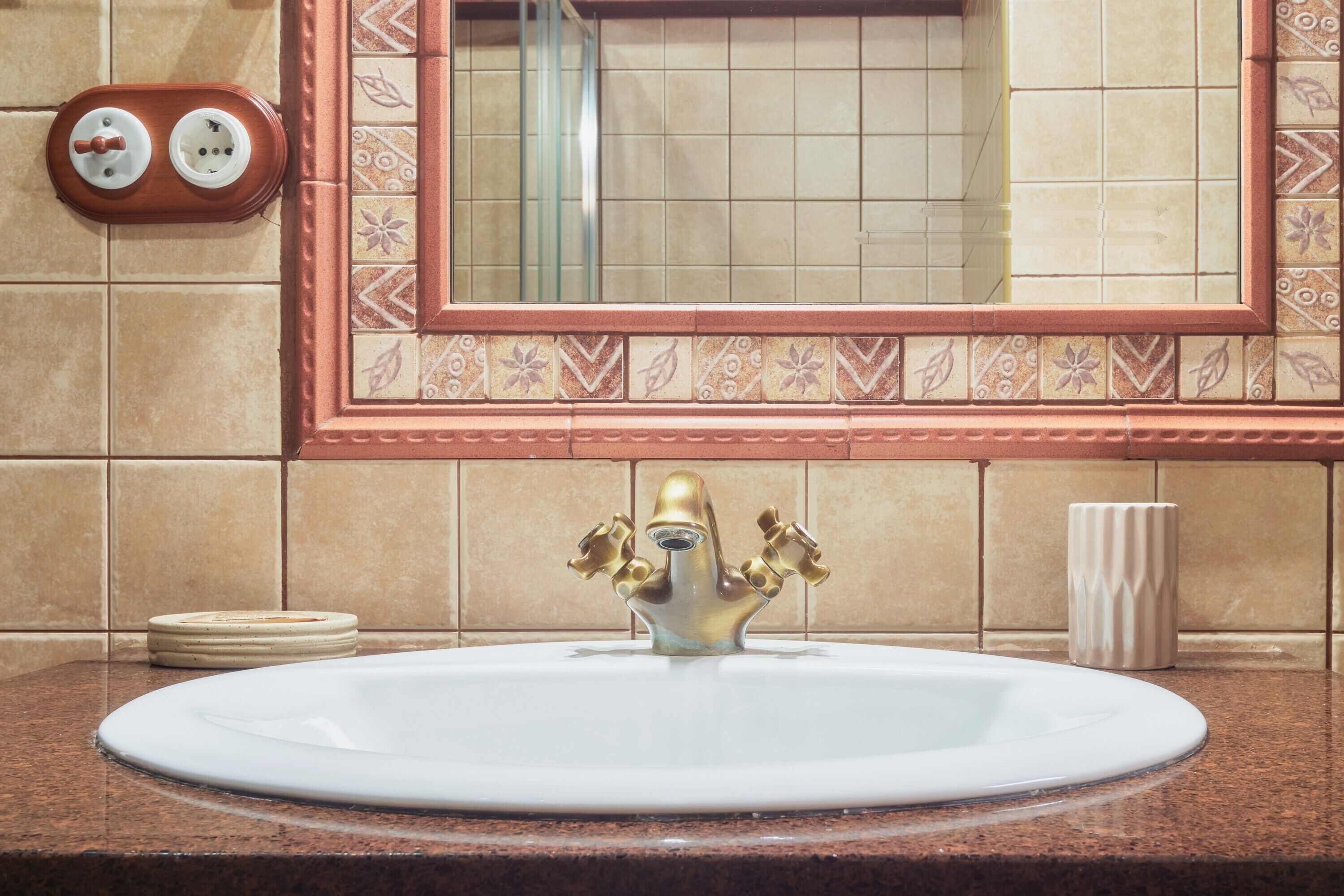 A bathroom with a sink, mirror, and towel rack.