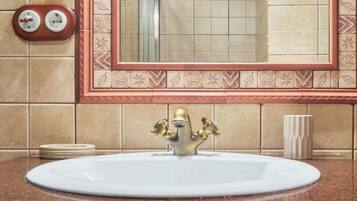 A bathroom with a sink, mirror, and towel rack.