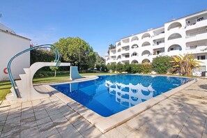 Une piscine à l’eau d’un bleu limpide, entourée d’une terrasse carrelée.