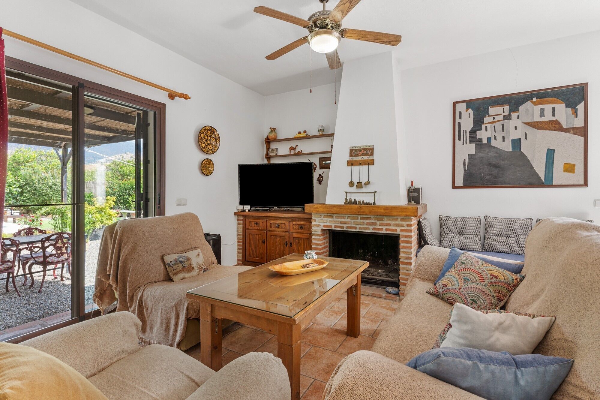 A living room with a fireplace, TV, and outdoor patio.
