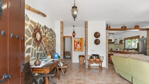 A spacious living area with a dining table, chairs, a sofa, and a kitchen in the background. - Country House 'Villa Pinale Álora' with Mountain View, Wi-Fi and Air Conditioning (Álora)